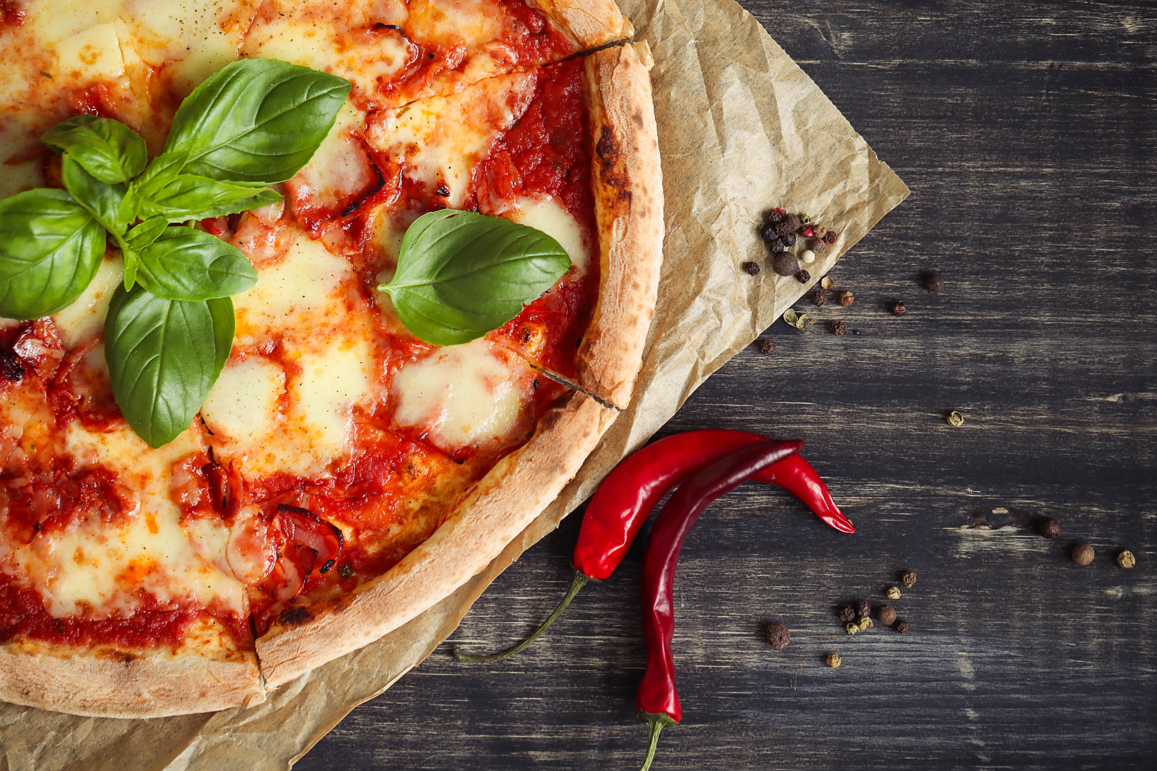 Pizza with mozzarella, fresh green basil and chopped red chilies