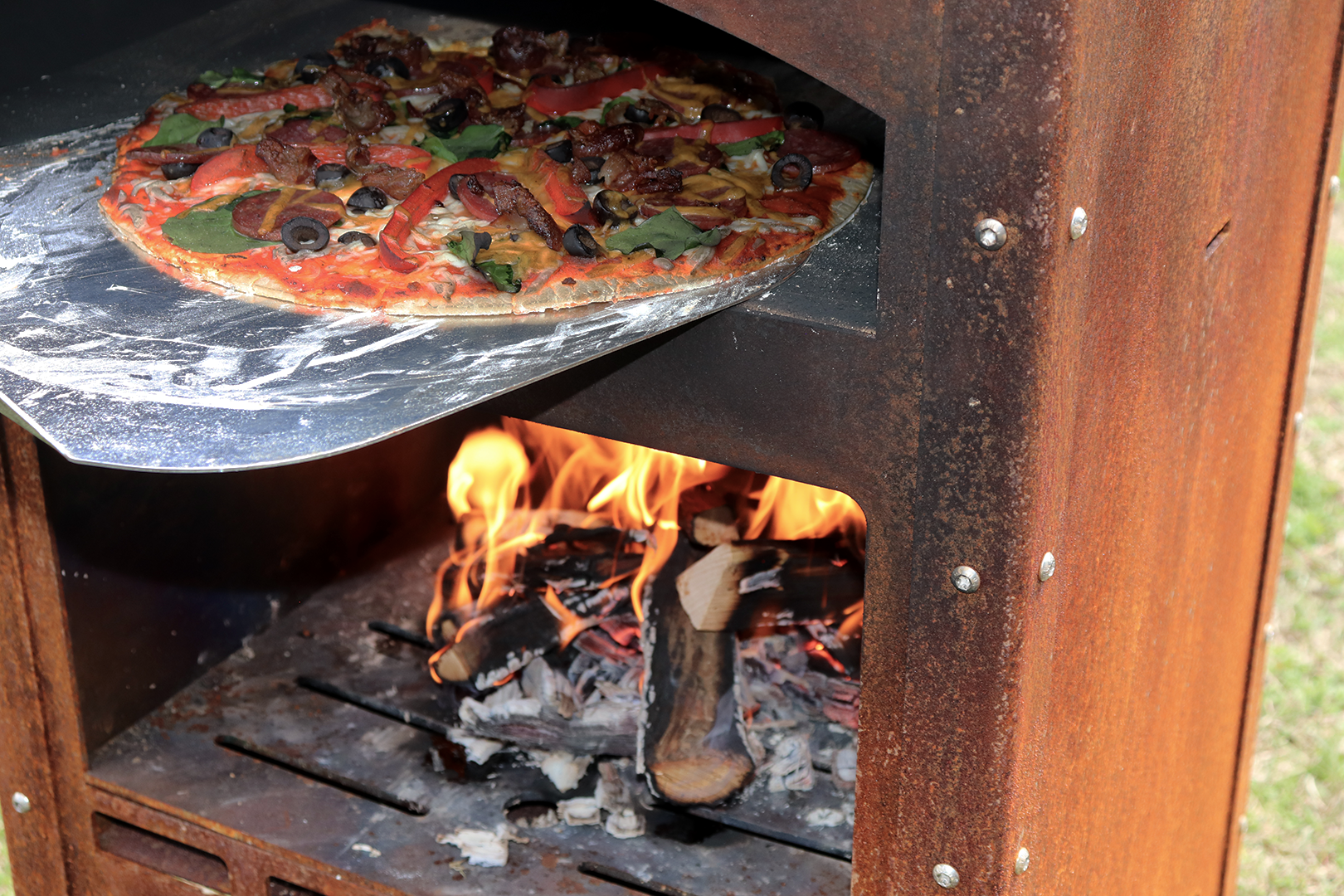 Getting as pizza ready for eating in a outdoor pizza oven